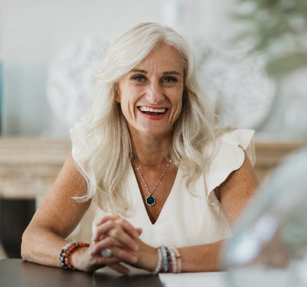 Helen Armstrong smiling warmly at a table in soft interior light.